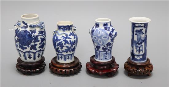 Four 19th century Chinese blue and white small vases, with hardwood stands tallest 9.5cm